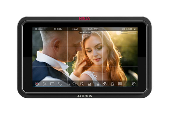 An Atomos Ninja monitor displaying a video of a man and woman in profile against a soft background.