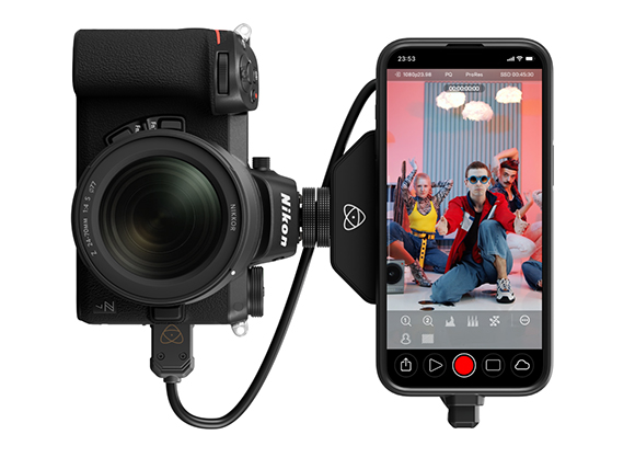 A Nikon camera mounted to a smartphone using a black bracket and cables.