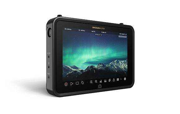 A black Shogun Ultra monitor displaying a landscape of mountains under a green aurora borealis.