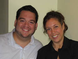 A smiling man in a white shirt and a woman in a black shirt posing together.