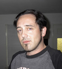 A man with dark hair and a goatee looking forward.