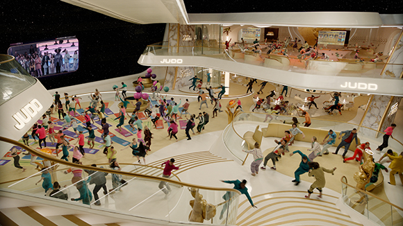 High-angle view of a multi-level, modern interior with many people walking on stairs and platforms.
