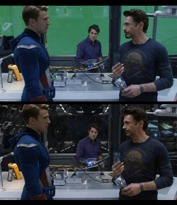 Two men in a high-tech lab talk while a third man stands in the background.