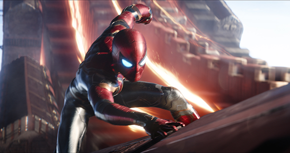 A superhero in a red and black suit crouches on a ledge amidst glowing orange light streaks.