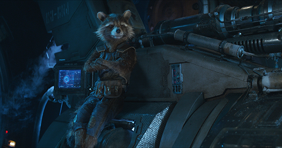 An anthropomorphic raccoon wearing a tactical vest sits on dark, complex machinery in a dimly lit setting.