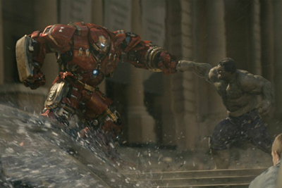 A massive red mechanical suit punches a large, muscular grey creature in a city setting.