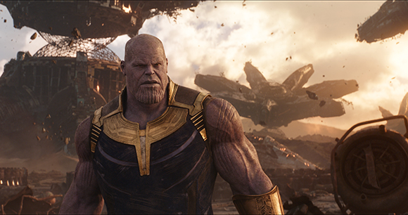 A muscular, purple-skinned character with a ridged chin stands before a hazy, debris-filled battlefield.