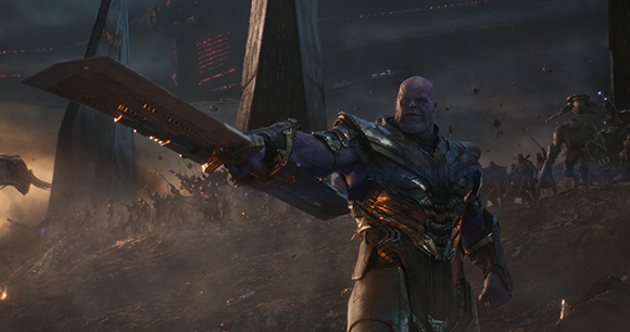 A large purple-skinned warrior holds a massive double-edged sword amidst a chaotic battlefield.