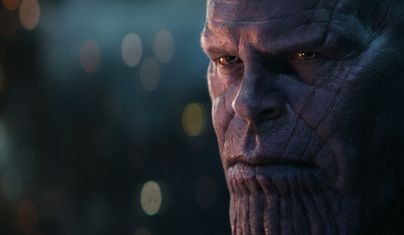 Extreme close-up of a purple-skinned character with deep facial ridges and a serious expression.