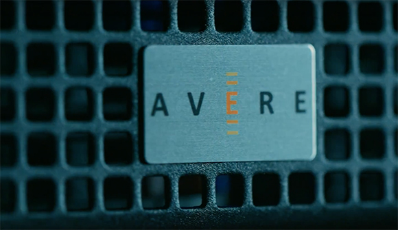 A rectangular metal plate with the text 'AVERE' featuring a stylized orange 'E' on a dark perforated surface.