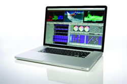 A silver laptop open on a white surface, displaying a video editing interface with color wheels and timelines.