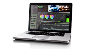 A silver laptop open on a white surface, displaying a complex video editing and color grading interface.