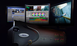 Three monitors showing video editing interfaces and footage above a Nitris hardware unit in a dark setting.