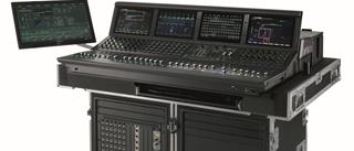 A large black digital audio mixing console with multiple screens and control knobs on a flight case.