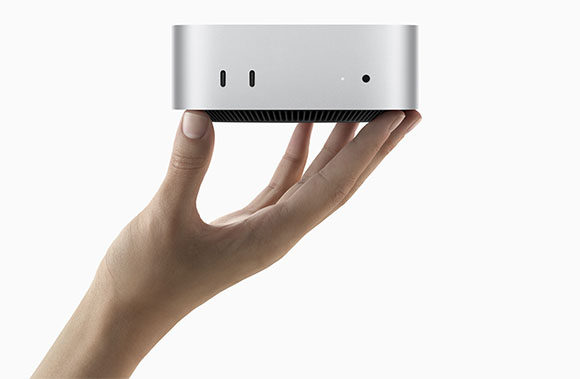 A person's hand holds a small, rectangular silver electronic device against a white background.