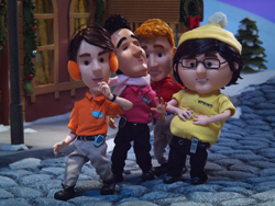 Four stylized animated characters walking on a cobblestone path in a snowy village.