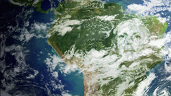 Satellite view of South America with a faint human face superimposed over the clouds and land.