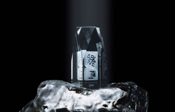 A clear, geometric glass trophy resting on a jagged block of ice against a black background.