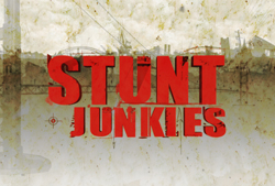 Red block text reading STUNT JUNKIES over a sepia-toned, gritty urban skyline.