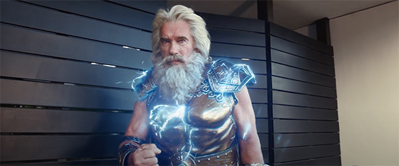 A man with long white hair and a beard wearing golden armor with blue lightning glowing around him.