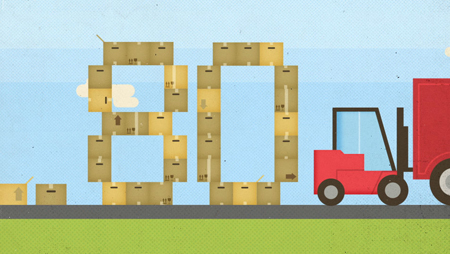 Cardboard boxes arranged to form the number 80 next to a red forklift on a flat landscape.