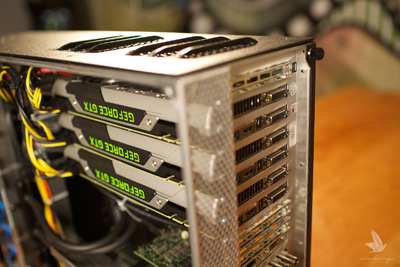 Close-up of a computer chassis housing four GeForce GTX graphics cards installed side-by-side.