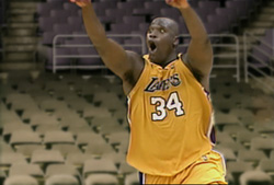 A basketball player in a yellow Lakers jersey with number 34 raises his arms in celebration.