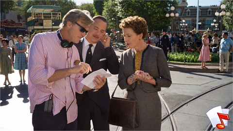 A man in a pink striped shirt shows a paper to a man in a suit and a woman in a grey jacket outdoors.