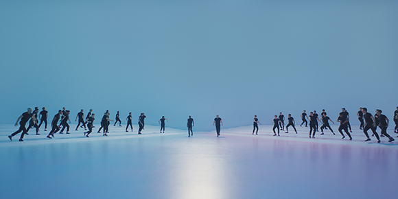 A line of silhouetted figures running across a flat, blue expanse under a clear sky.