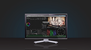 A computer monitor displays a video editing interface with color wheels, timelines, and a video preview.