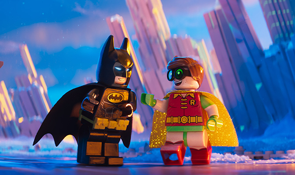 LEGO Batman and Robin minifigures standing side-by-side against a blurred cityscape background.