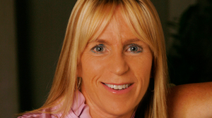 A smiling blonde woman with bangs looking directly at the camera.