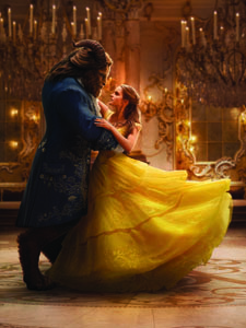 A large beast in a blue coat dances with a woman wearing a voluminous yellow ballgown in a grand ballroom.
