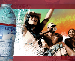 A bottle of Crystal Geyser water in the foreground with people smiling and drinking in a sunny background.