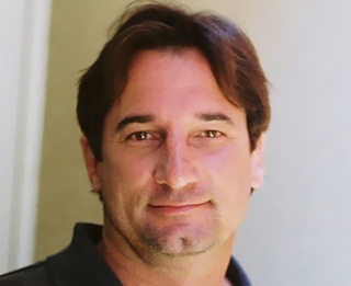 A man with dark brown hair and brown eyes looking directly at the camera.