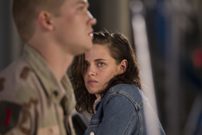 A man in camouflage profile and a woman in a denim jacket looking forward with a serious expression.