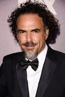 A man with curly dark hair and a salt-and-pepper goatee wearing a black tuxedo and bowtie.