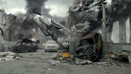 A war-torn street filled with debris, smoking wreckage, and a large overturned vehicle under a cloudy sky.