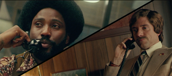 Split screen showing a Black man with an afro and a white man with a mustache both talking on landline phones.