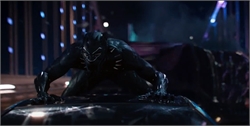 A figure in a black panther suit crouches low on a dark, reflective surface under dim lights.