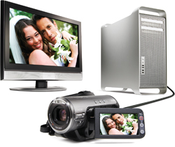 A computer monitor, silver desktop tower, and a camcorder showing a wedding couple on their screens.