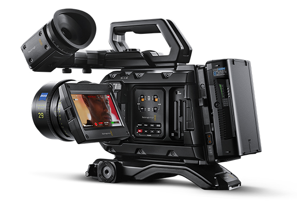 A professional black cinema camera equipped with a large lens, an attached monitor, and a top handle.