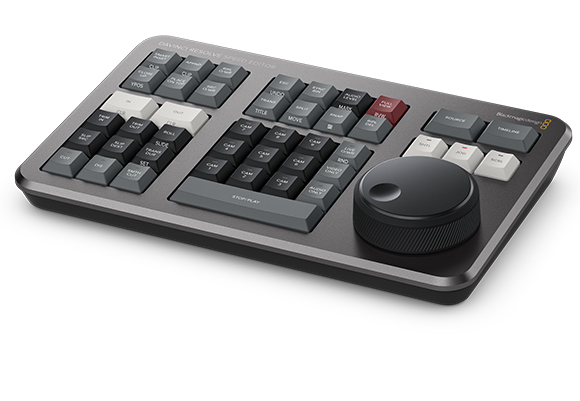A dark gray video editing control surface with various buttons, sliders, and a large rotary dial.