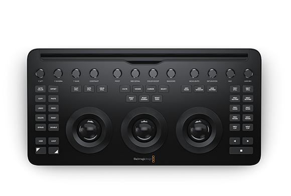 A black professional color grading control surface with various buttons, knobs, and three large trackballs.