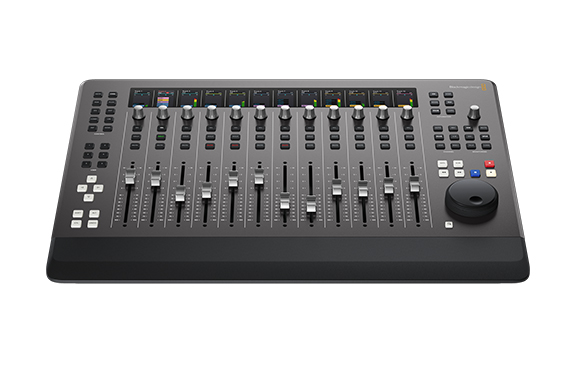 A black video production control surface with multiple faders, knobs, buttons, and small digital displays.