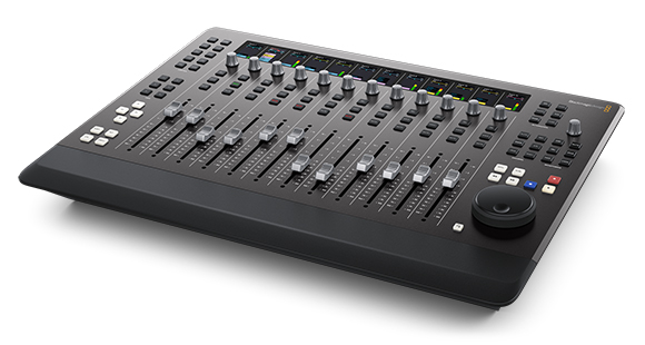 A black digital audio mixing console with numerous sliders, knobs, buttons, and small digital displays.