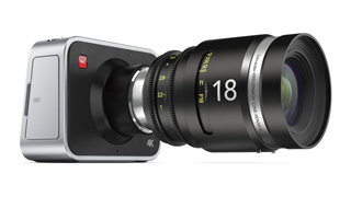 A silver and black digital camera body attached to a large black 18mm lens against a white background.