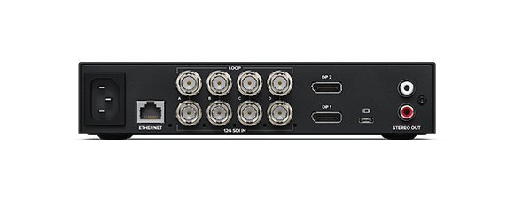 Rear view of a black electronic device showing power, ethernet, SDI, DisplayPort, and stereo audio ports.