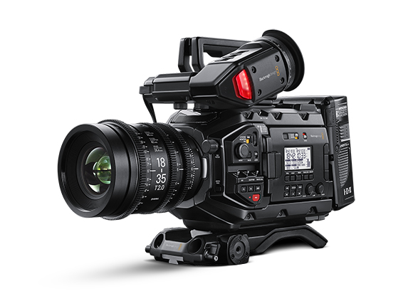 A professional black digital cinema camera with a large lens and mounted on a tripod base against a white background.