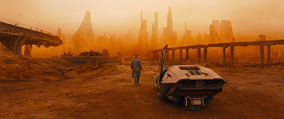 A man in a trench coat walks away from a futuristic car with its door open, towards a ruined city skyline under an orange sky